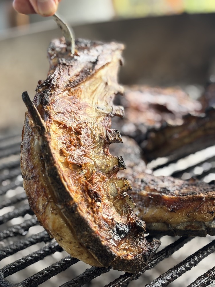 Falda de cordero dorándose sobre la parrilla